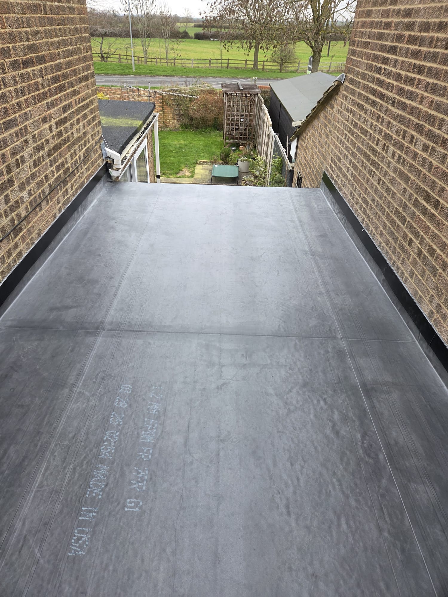 Completed EPDM flat roof on a rear extension overlooking open fields