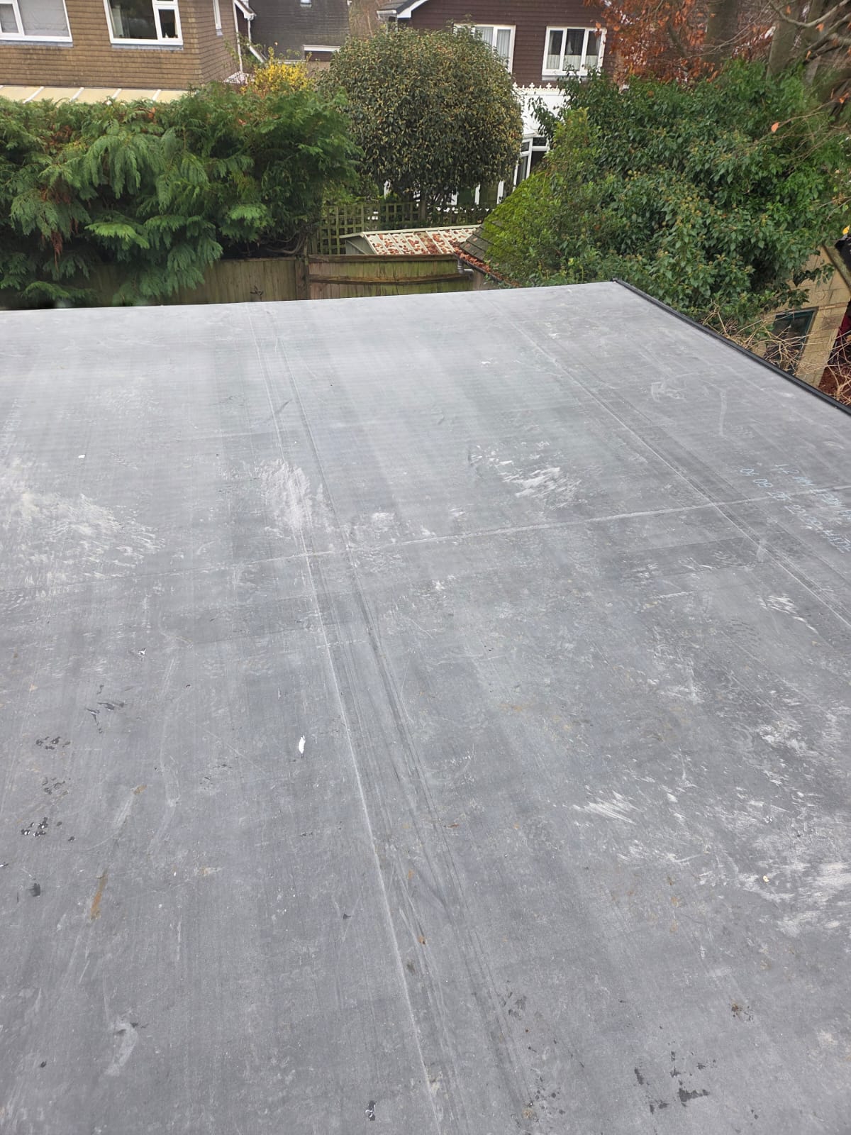 Completed EPDM flat roof viewed from above with brick parapet edges