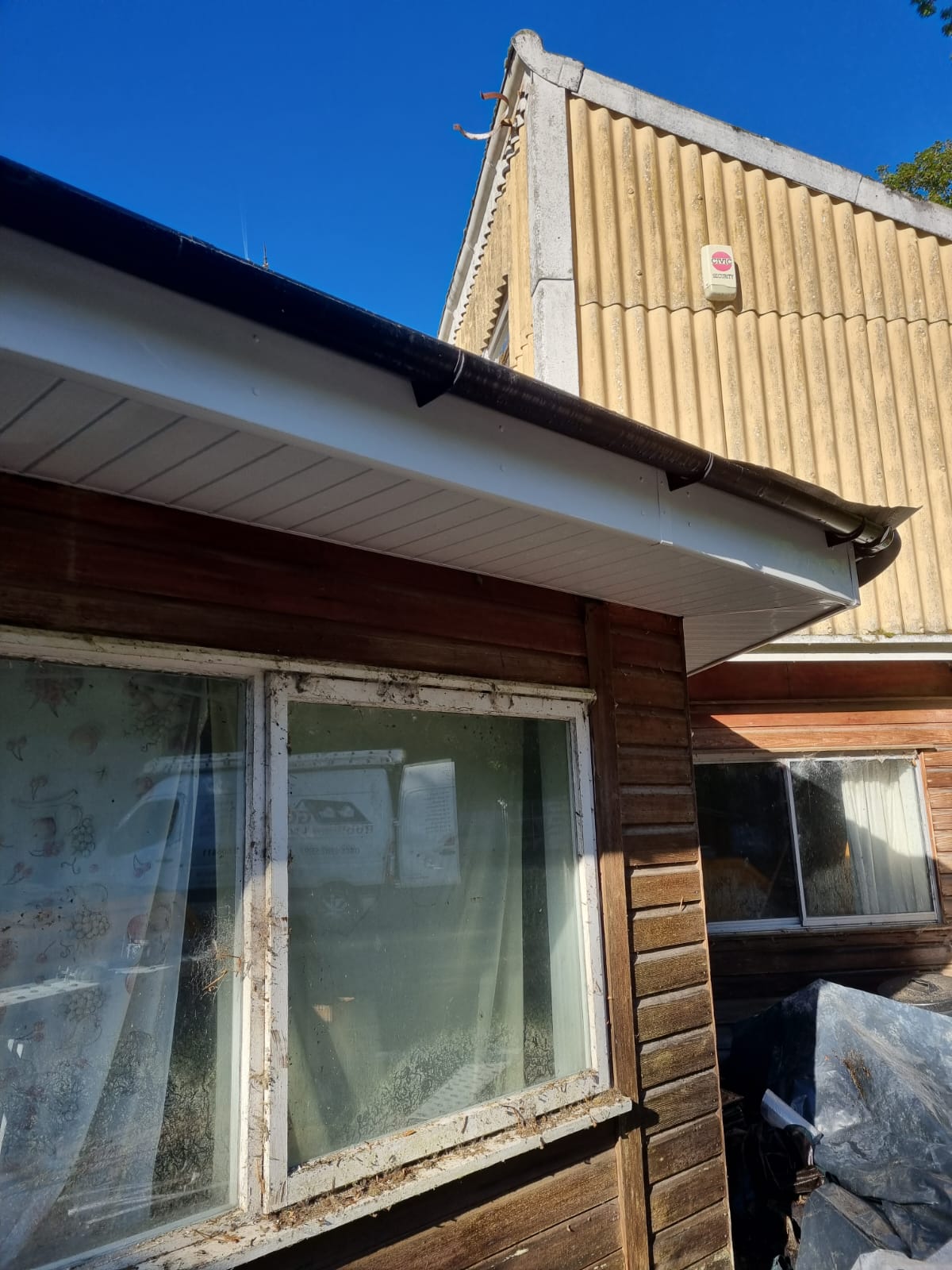 Replacement fascia and guttering fitted to an older outbuilding with corrugated cladding