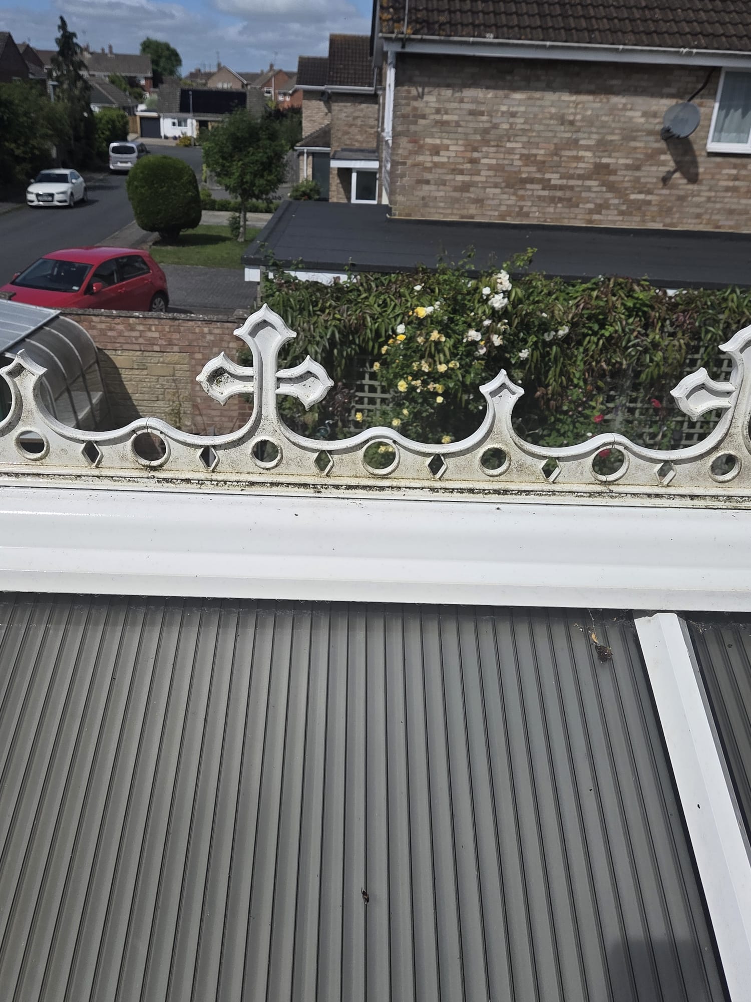 Ornate white uPVC cresting on a conservatory roof showing moss staining before cleaning