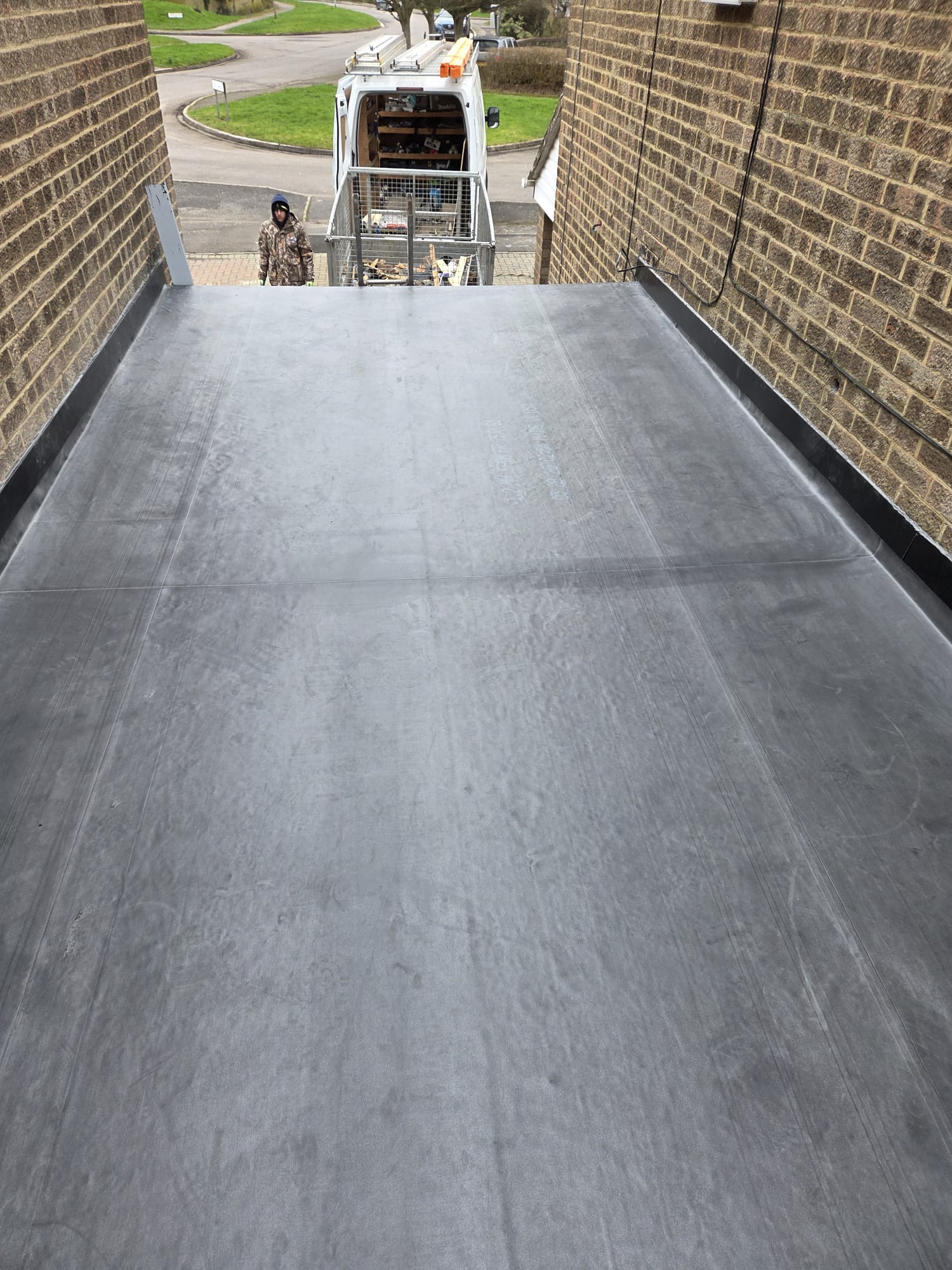 EPDM flat roof installation on a residential side extension with brick walls